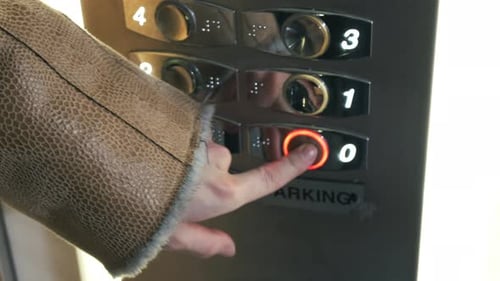 Eine Frau drückt die Kellerdecke des Aufzugs hoch