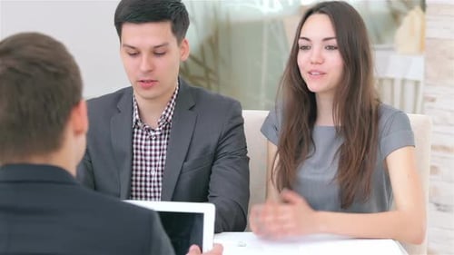 Junges attraktives Paar berät sich über ihr Geschäftsprojekt