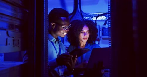 Data Technicians Working in Server Room at Night