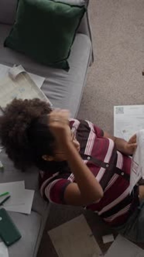 Vertical of Worried Woman Sorting Overdue Bills with Laptop at Home