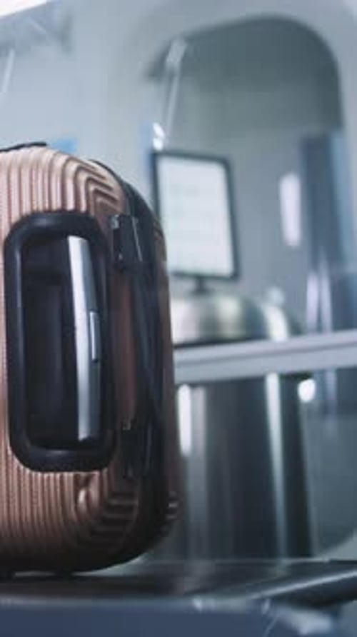 Airport Security Checkpoint Passenger Puts Suitcase on Xray Conveyor Belt for Luggage Scanning