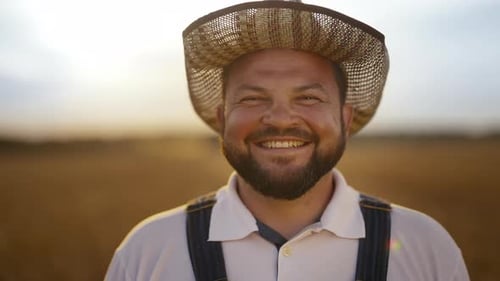 Bearded Farmer Smiling in Field at Sunrise