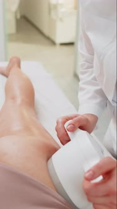 Anticellulite Massage Cosmetologist Makes a Woman Cavitation Vacuum RF Lifting Spa Legs Procedure