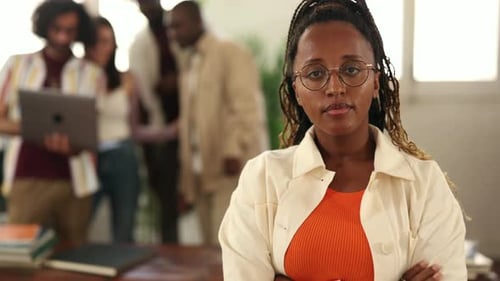 Confident young manager woman posing with her arms crossed in the office