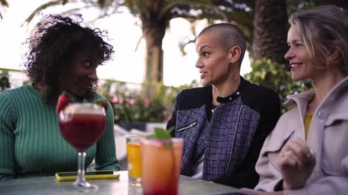 Three Cheerful Mature Women Drinking Cocktails or Mocktails Outdoors in a Terrace