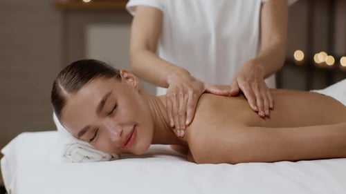 Woman Enjoying a Relaxing Back Massage at Spa