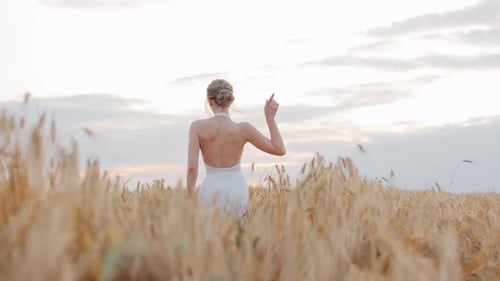 Seductive Woman in White Dress Dancing Amidst Field of Rye