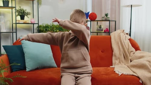 Boy Dancing Happily on Couch in Living Room