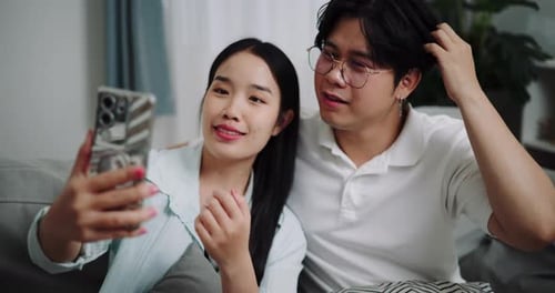 Happy young couple having fun video chatting with friend.
