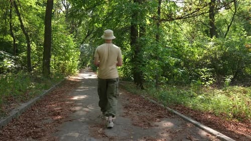 A Young Man is Walking in the Park