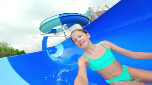 Girl Having Fun Going Down The Water Slide