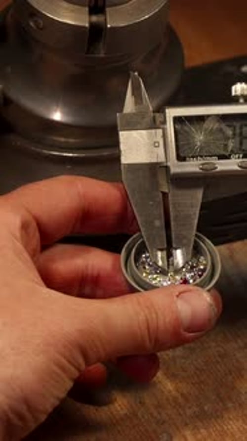Measuring Stones with Calipers in Jeweler's Workshop