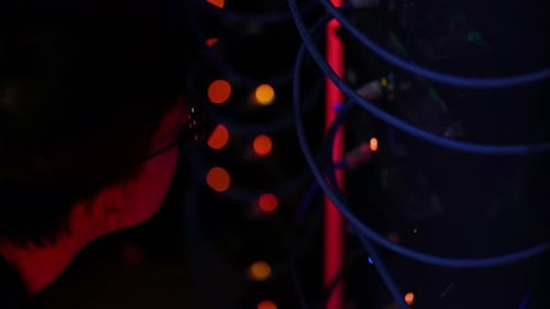 Close up of a man panicking in a server room with flashing red lights