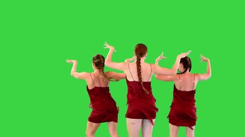 Three Caucasian Girls Dressed in Red Dress with Fringe Perform Some Concert Dance on a Green Screen