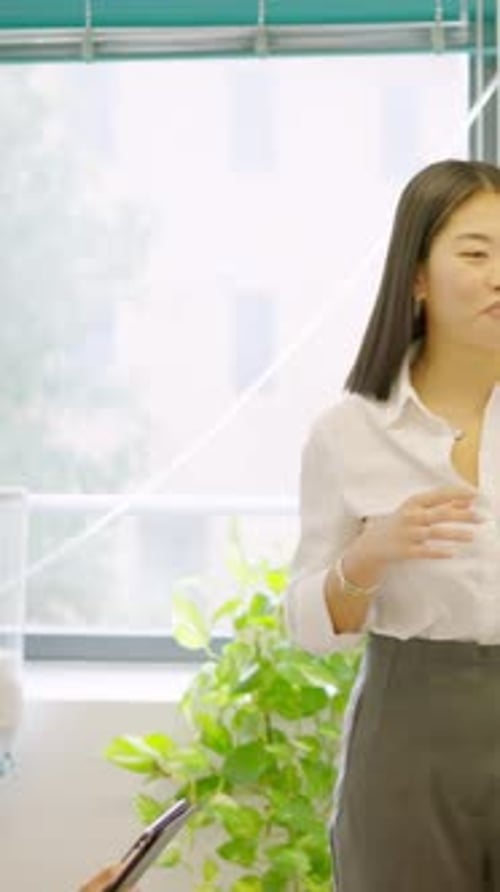 Colleagues Using a Graphing While Presenting Data in a Meeting