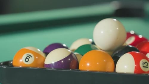 Closeup of Colorful Billiard Balls Neatly Arranged in Triangle Rack on Green Pool Table