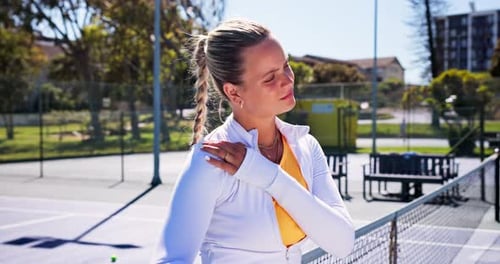 Woman, shoulder pain and sports injury with tennis, stretching for joint ache on court at fitness