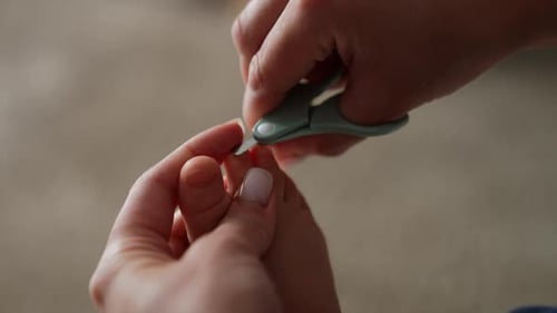 Adult Trims Baby's Toenails With Baby Scissors