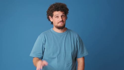 Happy man showing ok gesture isolated on blue background in studio