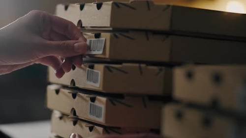 Pizzeria, Shef Chef Baker colle soigneusement une boîte à pizza à code-barres sur le lieu de travail de Baker au ralenti
