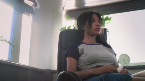 Depressed Teenager Sits in Chair During Therapy with Psychotherapist