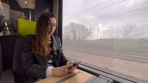 Frau benutzt Handy im öffentlichen Schnellzug