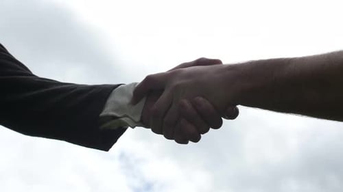 Hands Shake, Business Deal on Cloudy Day