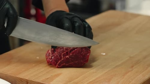 Chef Slicing Fresh Meat on Wooden Cutting Board