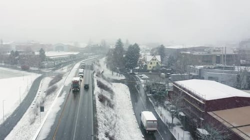 flying in an industrial area over a busy street in a snow blizzard in January.