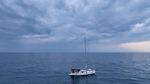 Luftaufnahme einer in der Bucht vor Anker liegenden Segelyacht mit klarem und türkisfarbenem Wasser bei Sonnenuntergang