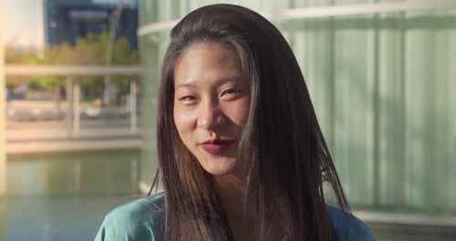 Portrait of a Beautiful Asian Woman Smiling and Looking at Camera Outdoors in the Student Campus