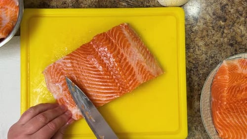 Preparing salmon fish fillets with a knife for further cooking. Top view.