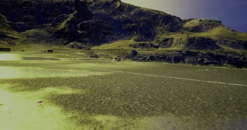 Serene Landscape with Rocky Hills and Empty Road Under Blue Sky