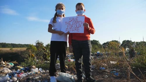 Children Hold Sign at Landfill