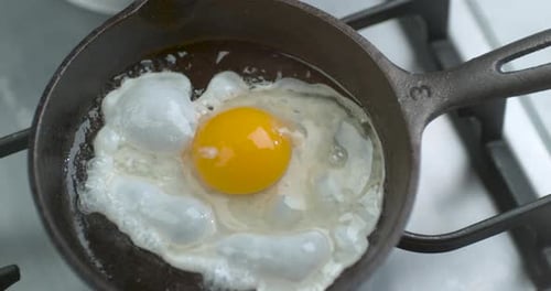 A Chef Fries an Egg, Sunny Side Up, in a Small Frying