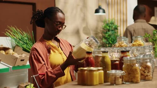 Woman Inspecting Jar in Food and Beverage Store