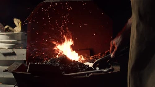 Blacksmith Tending Fiery Forge at Night