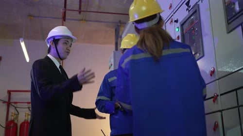 Engineers Inspecting an Electrical Panel in Dim Light