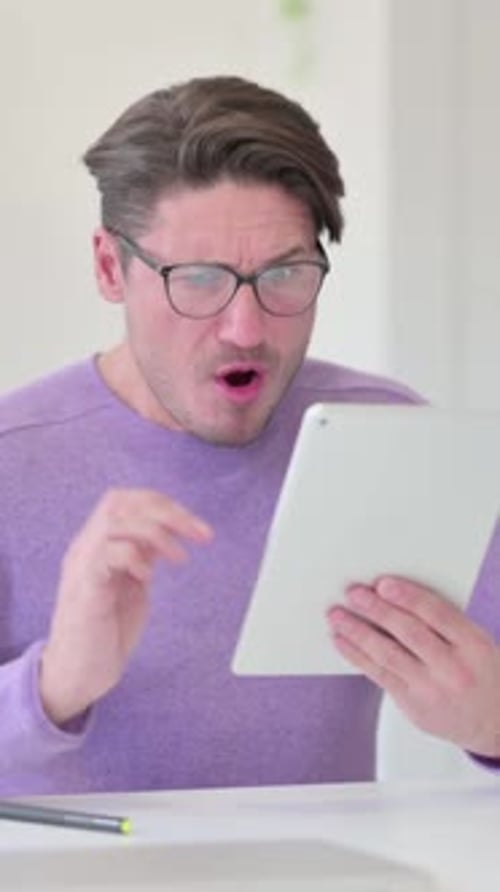 Surprised Man Looking at a Tablet Device