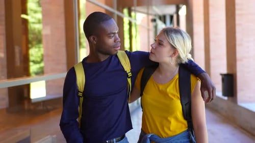 Casal multiétnico abraçando uma caminhada pela universidade