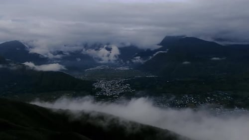 Vista aérea: foto em movimento, acima da névoa na colina de Pergasingan, vila de Sembalun e nuvens na parte de trás