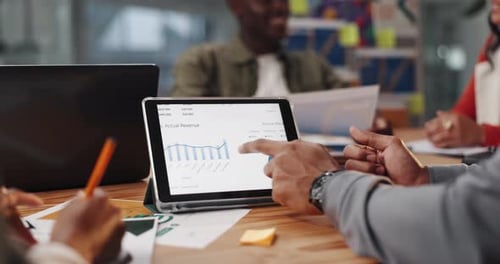 Business Team Meeting Reviewing Charts on a Tablet