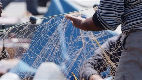 Fisherman Is Repairing Fishnets On Fishing Boat In Dock 5