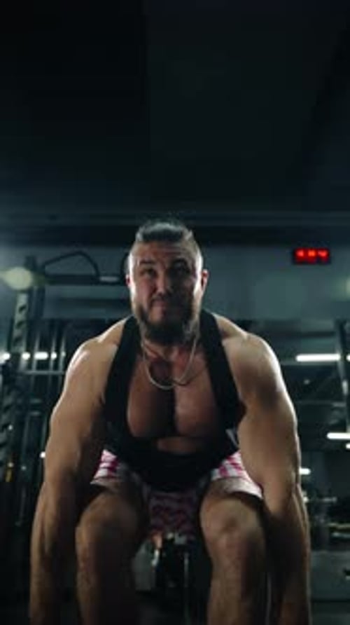 Intense Closeup of a Muscular Athlete Performing Heavy Deadlift Reps in a Dimly Lit Gym Showcasing