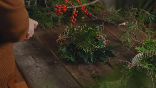 Woman makes Christmas floral wreath in workshop. Eco friendly Christmas decoration
