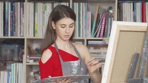 Focused Young Woman Passionately Painting at an Art Workshop