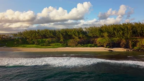 Tranquil Island Beachfront with Powerful Surf Breaking Against Tropical Shoreline at Golden Hour