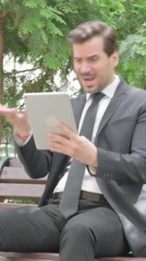 Man in Suit Using Tablet on Park Bench