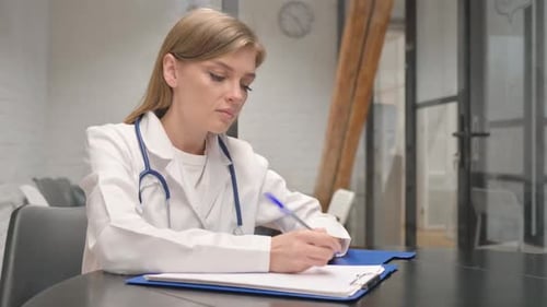 Female Doctor Writing Medical Report in Hospital