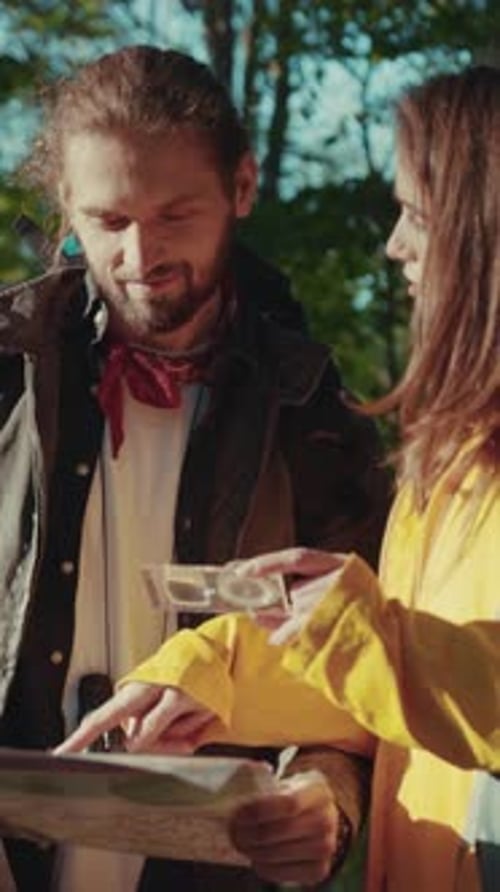 Couple Navigating with Map in Forest Sunlight